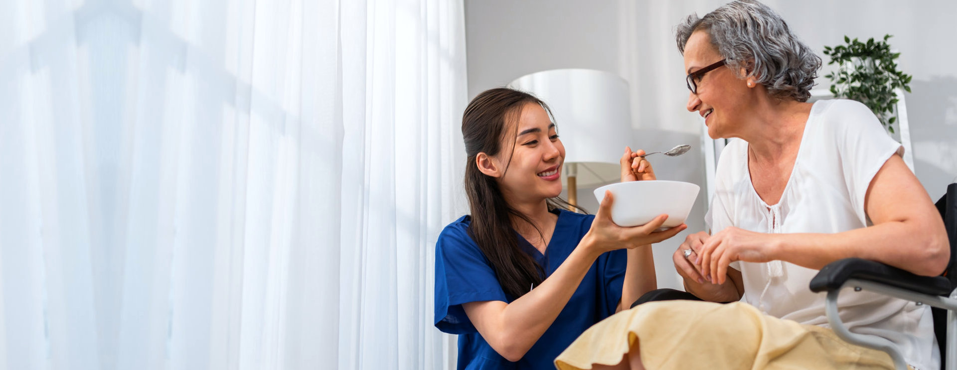 aide feeding an elderly woman