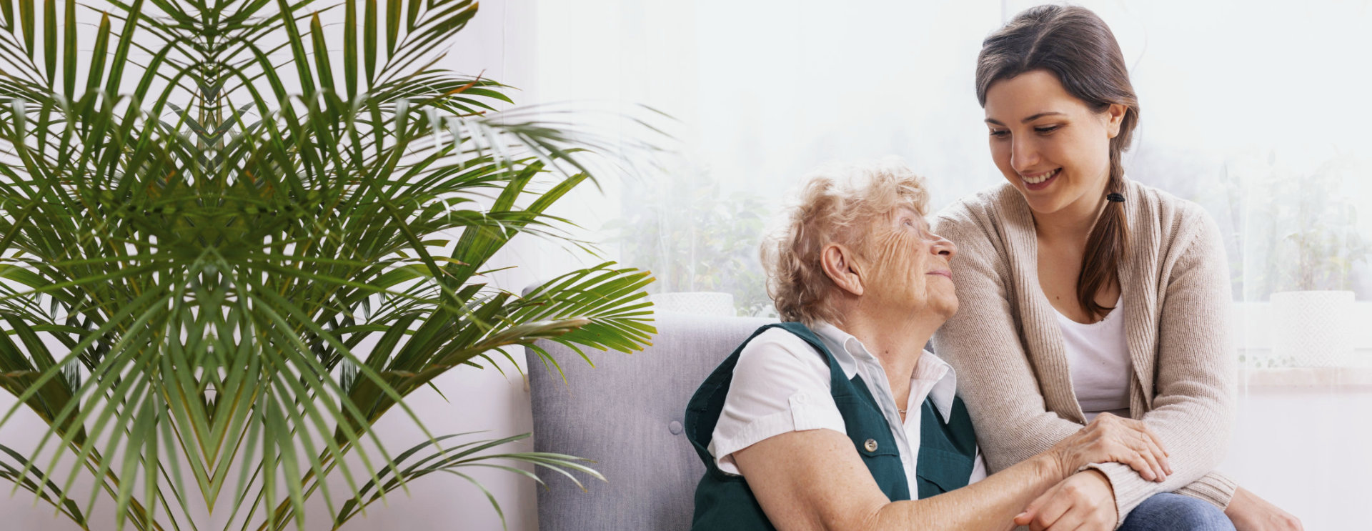 aide and elderly woman smiling at each other