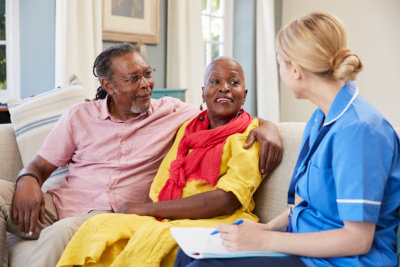 elderly couple talking to an aide